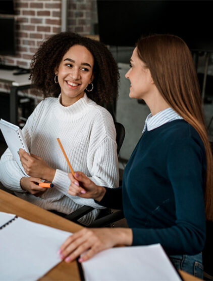 female-colleagues-talking-each-other-during-meeting