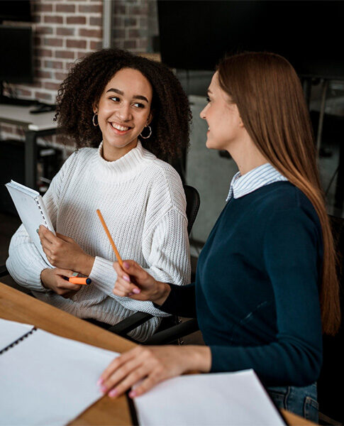 female-colleagues-talking-each-other-during-meeting